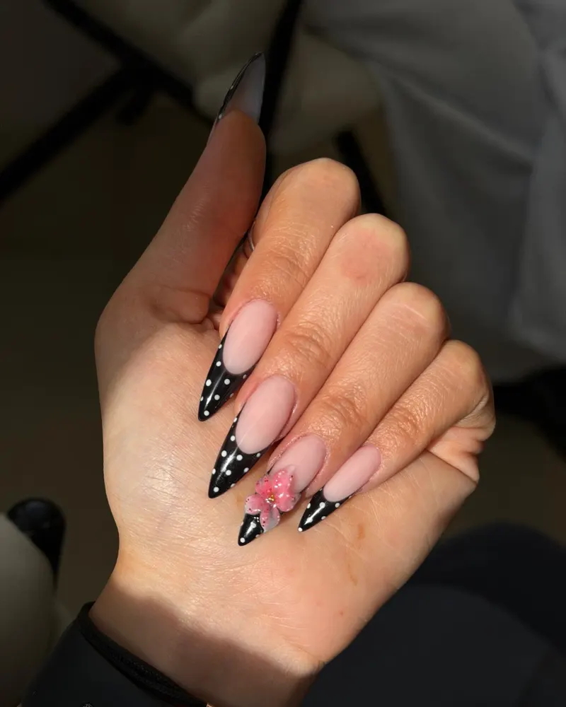 Black polka dot French tips with a flower accent